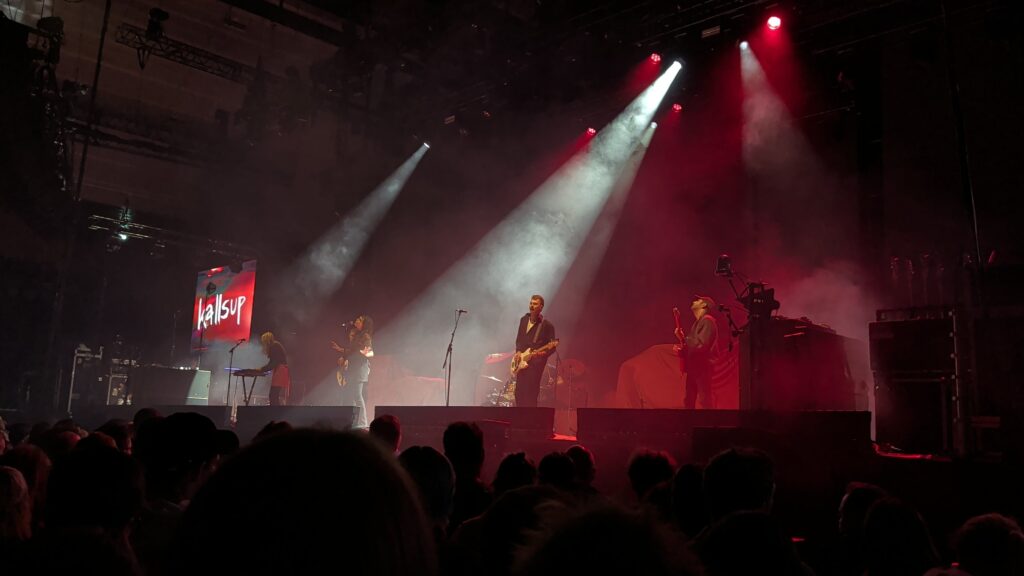 Kallsup in deep red stage light with spotlights crossing the stage at K.B. Hallen